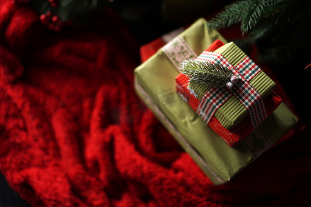 绿色的圣诞礼盒摄影照片_圣诞树下漂亮的圣诞绿色礼盒，铺着红毯