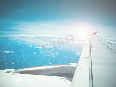 喷气式飞机机翼的镜头光晕和视图与云模式
