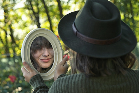 在森林里照镜子的年轻女子