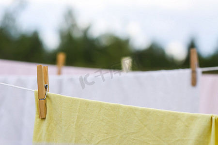 夏天衣服摄影照片_户外晾衣绳上挂着洗过的棉床单