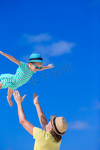 快乐的爸爸在海滩度假时和小孩玩得开心