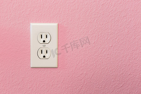 在五颜六色的粉红色墙壁上的电源插座