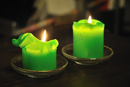 深色背景中熔化的绿色蜡烛