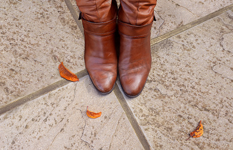 棕褐色皮靴的脚趾在混凝土上