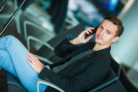 浅谈智能手机在机场内旅行的城市商人。
