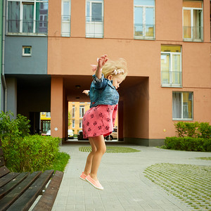 快乐的小孩，金发蹒跚学步的女孩跳跃