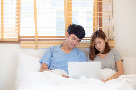 浏览互联网摄影照片_美丽的年轻亚洲夫妇微笑浏览互联网看 mo