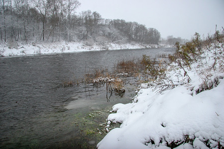在冬天，雪覆盖着森林和河道的景观。