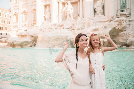 古代钱币摄影照片_年轻漂亮的女人和小女孩靠近喷泉 Fontana di Trevi