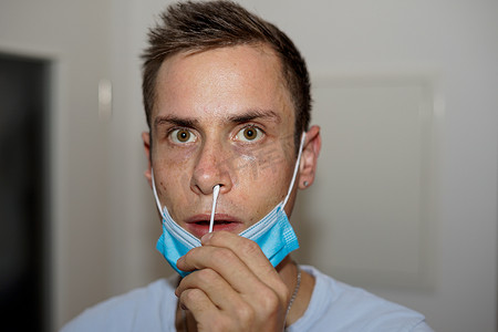 医用外口口罩摄影照片_一个戴着医用防护面具的男人的肖像接受鼻腔