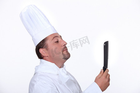 厨师用刀看着自己的倒影