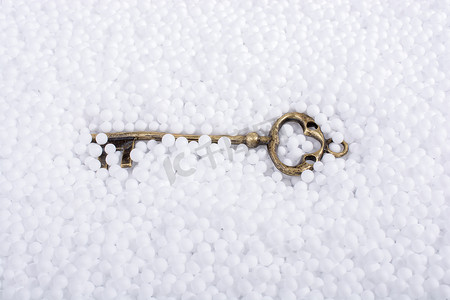 泡沫球摄影照片_白色聚苯乙烯泡沫球上的复古钥匙