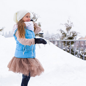冬天在户外玩雪球的可爱小女孩