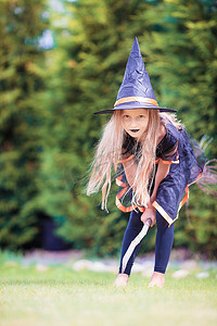 万圣室外摄影照片_万圣节快乐的小女巫拿着扫帚。