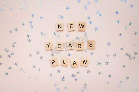 新年计划摄影照片_铭文新年计划从浅粉色背景上的木块。