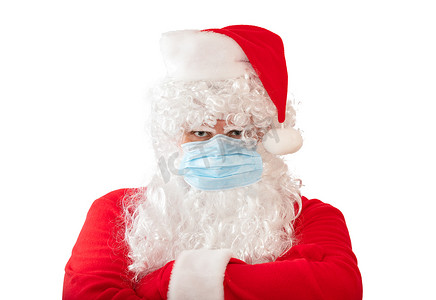 一个身穿圣诞老人服装、戴着医用面具、双臂交叉在胸前的男子，在白色背景中被隔离。