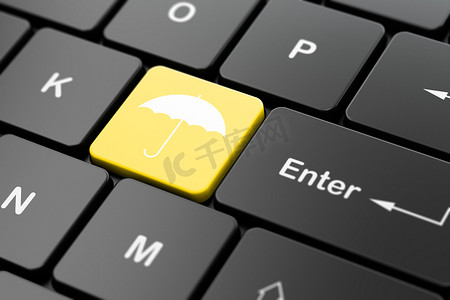 黑色的雨伞摄影照片_安全理念：电脑键盘背景上的雨伞
