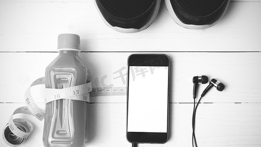 手机黑色苹果手机摄影照片_跑鞋、橙汁、卷尺和手机黑色和白色