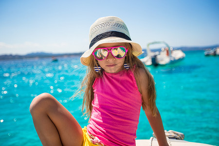 可爱的游艇摄影照片_可爱的小女孩享受在公海乘船航行