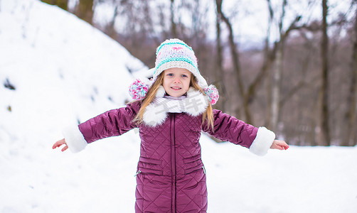 可爱的快乐小女孩在冬天的雪天户外玩得开心