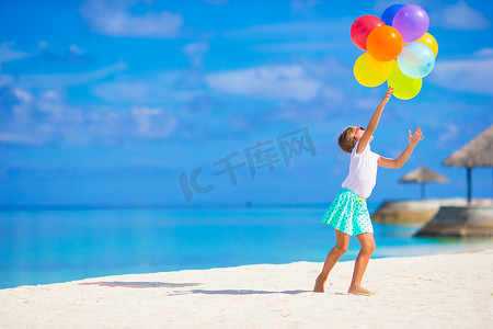 蓝色可爱风摄影照片_可爱的小女孩在沙滩上玩气球