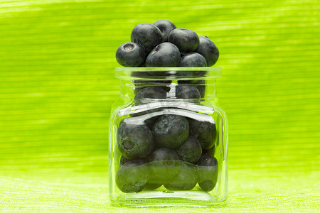 蓝莓味道摄影照片_绿色背景下银行里的蓝莓
