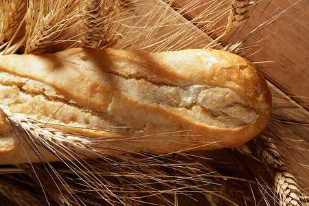 在木桌上放面包，上面放着小麦穗