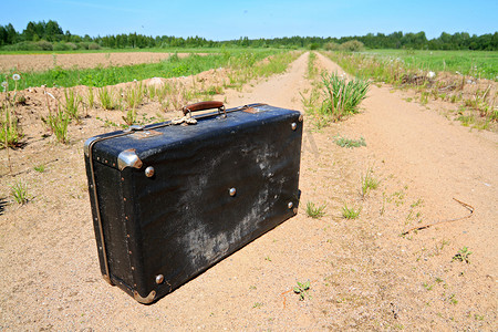 乡村道路上的旧手提箱