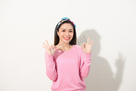 年轻漂亮的亚洲女人用两只手做出 OK 的手势。