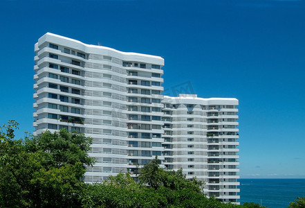 海边高层建筑摄影照片_海边的两栋公寓楼