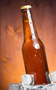 啤酒水滴摄影照片_一瓶带水滴和冰的新鲜啤酒，有文字空间