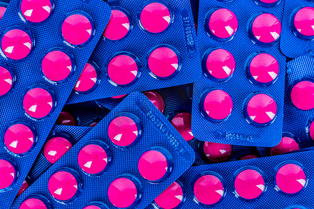 蓝色泡罩包装中粉红色药丸包装的布洛芬堆的完整框架。