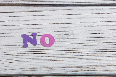 no摄影照片_白色木板上用彩色字母组成的彩色单词 no