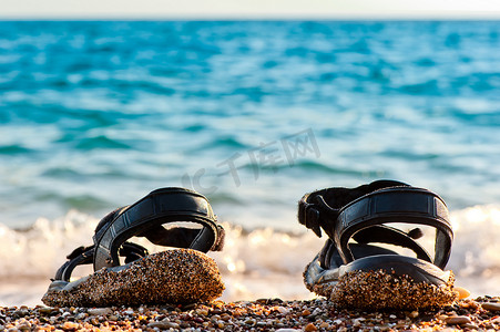 沙滩鞋摄影照片_在海边沙滩上的沙滩鞋。