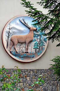粘土，墙上的一幅大画，上面有一只棕色的鹿和几棵树
