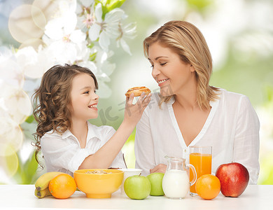 水果新鲜不新鲜摄影照片_吃早餐的愉快的母亲和女儿