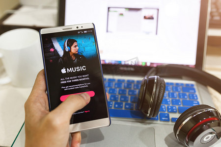 男子手持 Apple 音乐应用程序的屏幕截图显示在 Andro 上