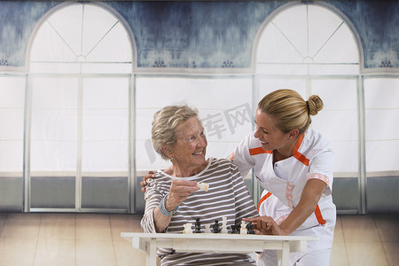 思家摄影照片_在养老院和护士玩耍的老年妇女