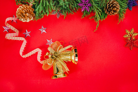 红色背景上带锥体和金铃的圣诞杉树