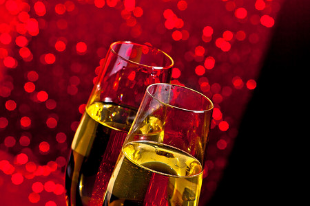 深红色浅景背景上带金色气泡的香槟长笛