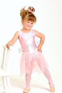 穿着粉红色芭蕾舞裙跳舞和微笑的小女孩