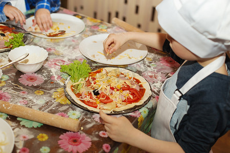 砥砺奋进谱新篇摄影照片_孩子们做披萨。