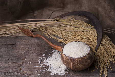 木碗中的白米和旧木背景中的水稻