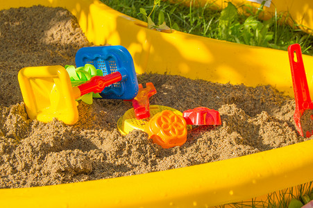沙滩上的一组彩色塑料玩具，夏季阳光日的儿童沙箱
