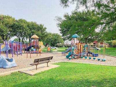 美国德克萨斯州理查森住宅区附近彩色游乐场的空金属长凳