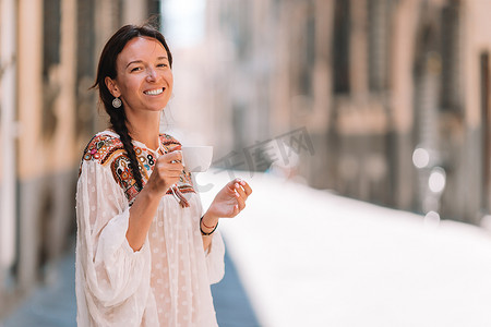 在欧洲街头散步的白人女孩喝着热饮咖啡