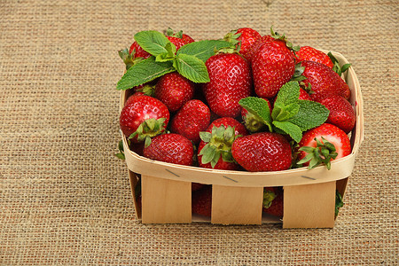 篮子里的草莓摄影照片_画布篮子里的草莓和薄荷叶