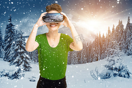 体验 VR 耳机眼镜的年轻女孩正在使用增强现实眼镜，在虚拟现实中，在山坡上，在冬天的阳光下