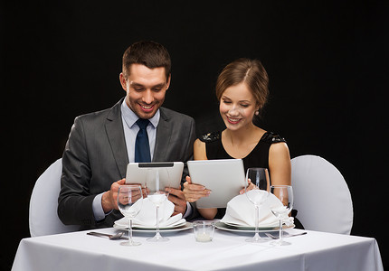 夫妇与餐厅的平板电脑上的菜单