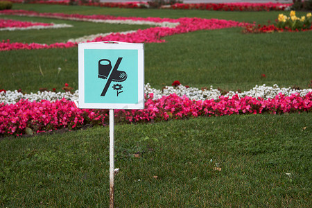 草坪花摄影照片_公园草坪上的告示牌，要求不要摘花。